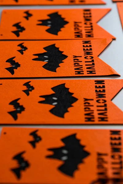 Halloween flags. Black and orange party flags for Halloween decoration on the white wooden desk. Happy halloween festive garland or banner, preparation for the holiday