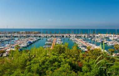 Deniz ve teknelerin arka planında yeşil ağaçlar var. Akdeniz 'de. Yaz tatili, tatil ve seyahat konsepti