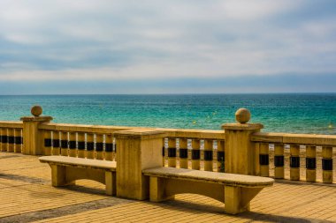 Sitges sahilindeki boş banklar, bir İspanyol Plajı Tatil Köyü. Yaz tatili, tatil ve seyahat