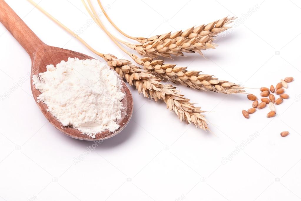 Ears of wheat and flour on the white background