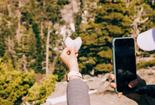 Woman Taking Picture Heart Made Snow Her Smart Phone — Stock Fotó