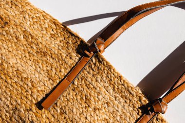 Beyaz arka planda saman plaj çantası, üst manzara. Yaz aksesuarları, doğal güneş ışığı