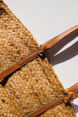 Beyaz arka planda saman plaj çantası, üst manzara. Yaz aksesuarları, doğal güneş ışığı