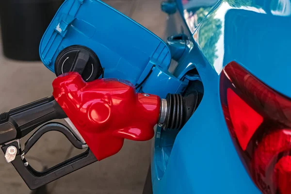 Close up of nozzle pumping gasoline into a car. Rising gas prices, global economic crisis concept