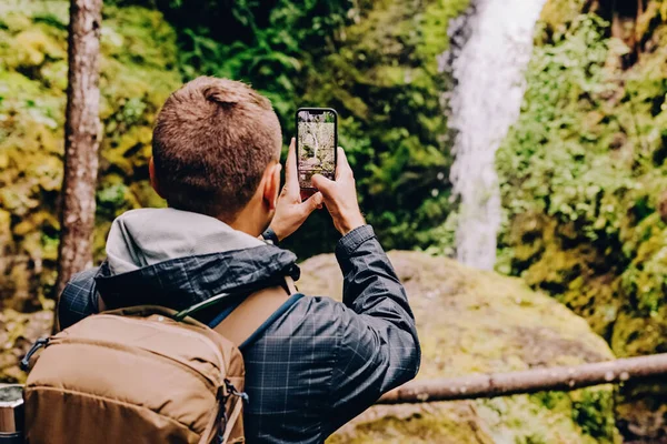 Man Taking Picture Scenic Waterfall His Phone — Stock Fotó