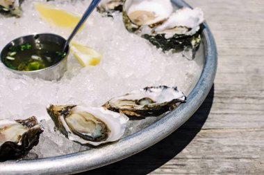 Dışarıdaki kafede buzda taze istiridye, güneş ışığı, yakın çekim.