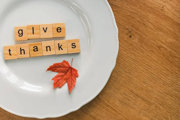 stock image Thanksgiving table setting concept. Small red leaf and text Give thanks on the white plate