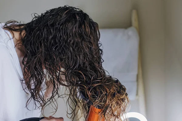 Woman diffusing her hair with dryer. Drying hair according to curly method for hair styling