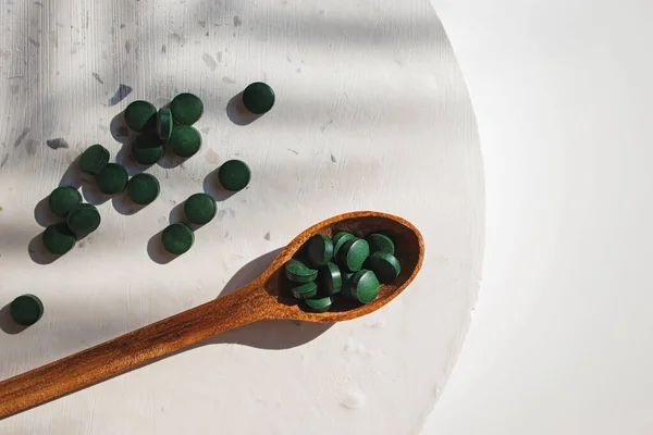 Zielone Tabletki Drewnianej Łyżeczce Spirulinie Lub Suplemencie Diety Chlorella Naturalne — Zdjęcie stockowe