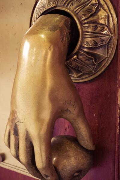 Bronze hand entry bell to ring in wooden door — Stock Photo, Image