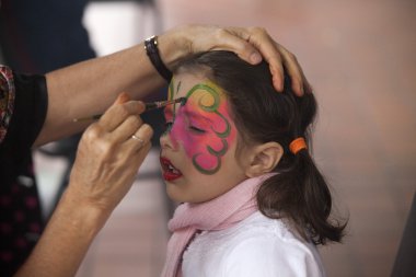 parti üzerine boya yüz olan küçük bir kız
