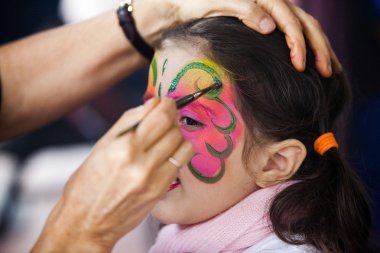 parti üzerine boya yüz olan küçük bir kız