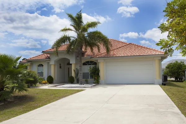 Lyxigt enfamiljshus med landskapsarkitektur på framsidan och blå himmel o — Stockfoto