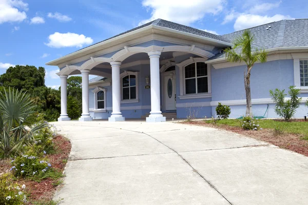 Casa familiar de lujo con jardinería en la parte delantera y cielo azul o — Foto de Stock