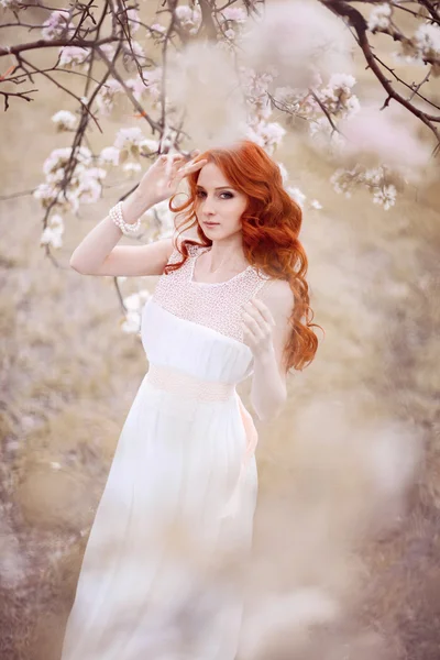 Beautiful woman in the flowering park — Stock Photo, Image