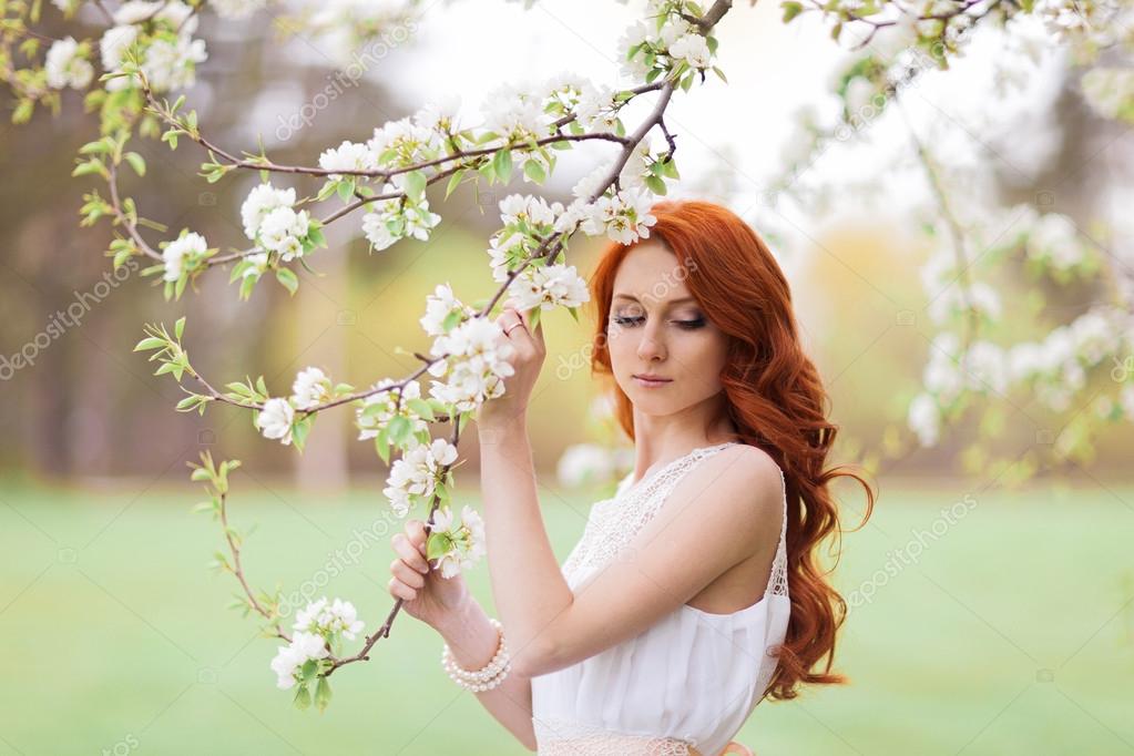 Beautiful woman in the flowering park