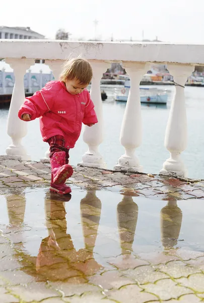 Baby girl walking in puddle — Stock Photo, Image