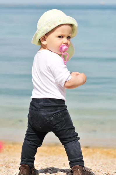 Bebé niña de pie cerca del mar — Foto de Stock