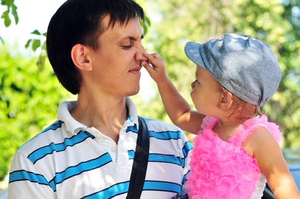 Baby flicka visar fars näsa — Stockfoto