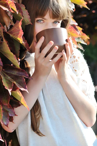 Young woman with mug of hot drink — Stock Photo, Image