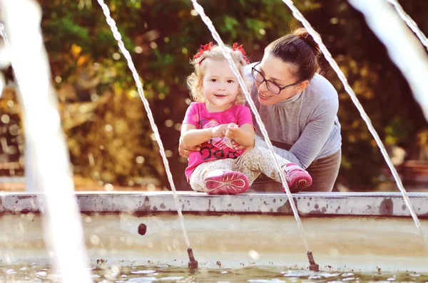 Mamma med barn flicka nära fontän — Stockfoto