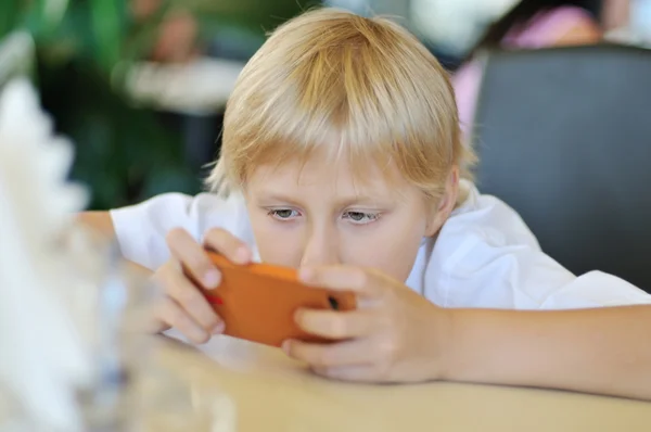 Мальчик играет телефон — стоковое фото
