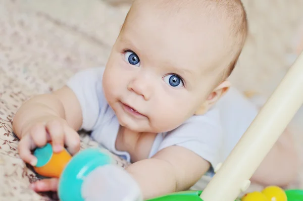 Bebê de olhos azuis com brinquedos — Fotografia de Stock