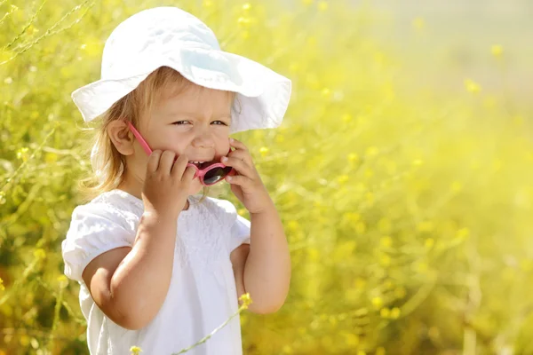 Laughing toddler in rape field — Stockfoto