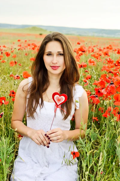 Meisje met hart in veld — Stockfoto