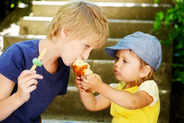 Schwester füttert Bruder — Stockfoto