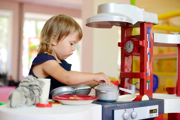 Girl playing toy kitchen — Stock Photo, Image