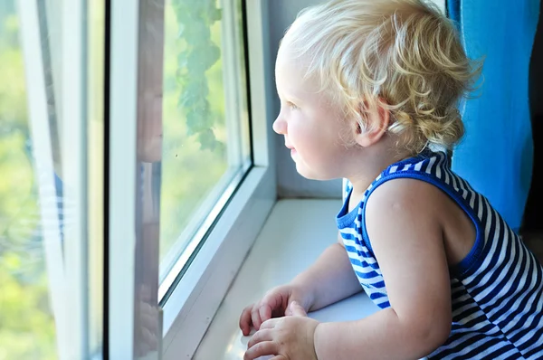 Ребенок смотрит в окно — стоковое фото