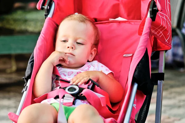 Schattige babymeisje in wandelwagen — Stockfoto