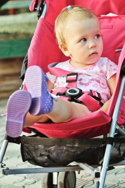 Baby in rode wandelwagen — Stockfoto