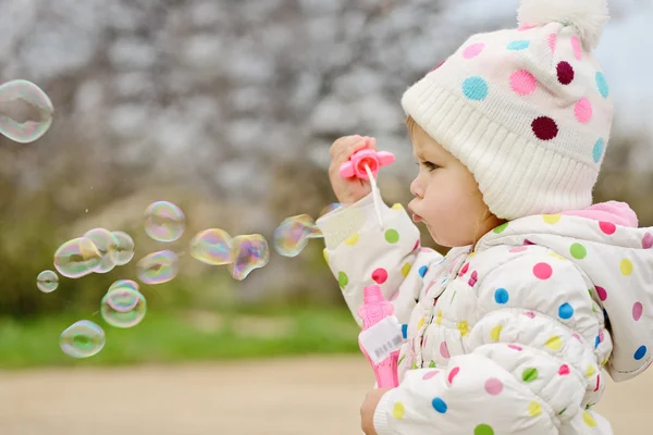 Toddler girl blowing soap bubbles — Stock Photo, Image