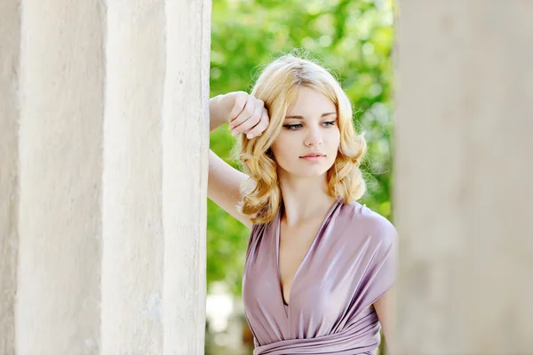 Tierna chica cerca de la columna — Foto de Stock