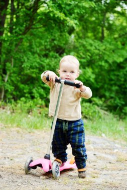 scooter üzerinde yürümeye başlayan çocuk