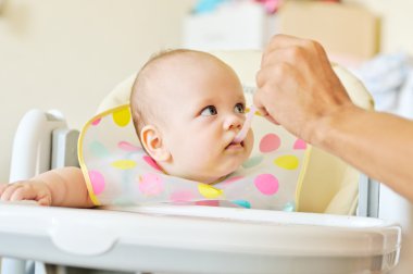 Baba bebeği besliyor  