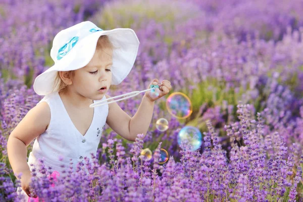 Toddler in field with bubbles — Stock Photo, Image