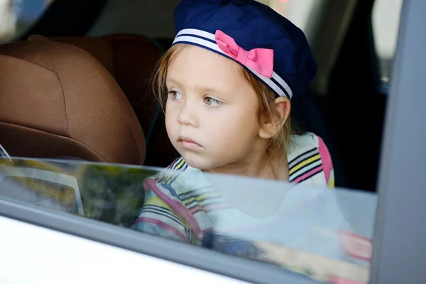 Girl looking in car window — Stock Photo, Image