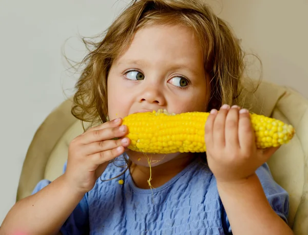 Девочка ест кукурузу — стоковое фото
