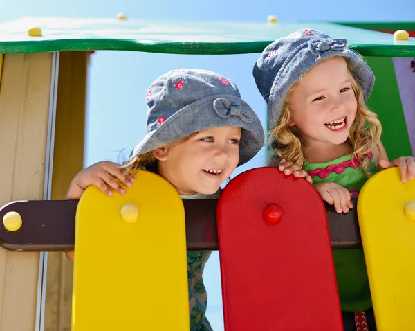 Crianças felizes no parque infantil — Fotografia de Stock