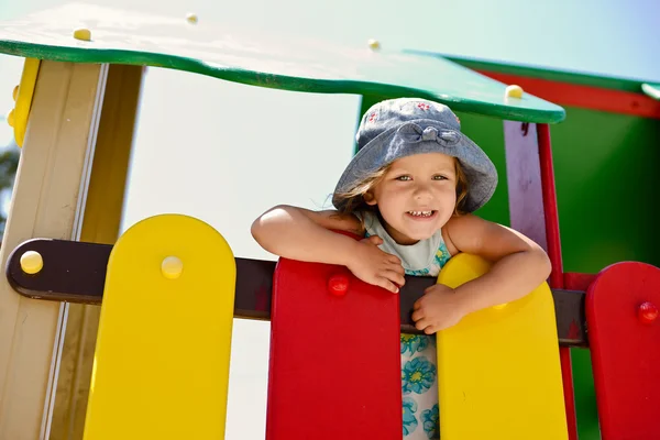 Счастливая девочка на детской площадке — стоковое фото