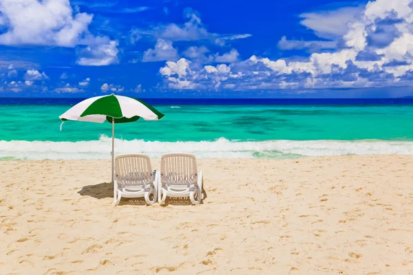 Stoelen en parasol op tropisch strand — Stockfoto