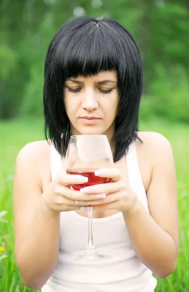 Het jonge meisje met een glas wijn — Stockfoto