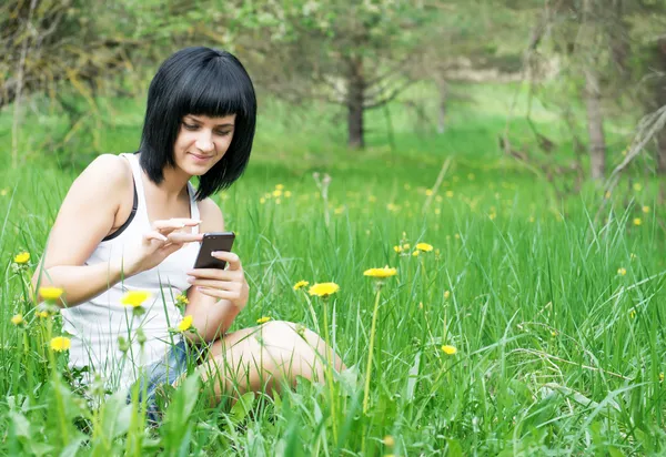 Woman enjoying the outdoors using her cell phone — Stock Photo, Image