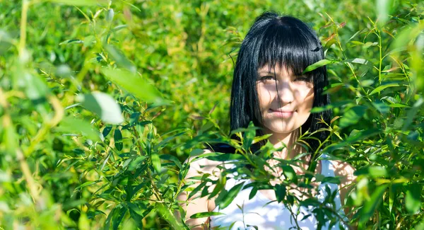 Belle fille dans le feuillage vert — Photo