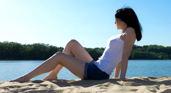 Девушка в солнечных очках на пляже — стоковое фото