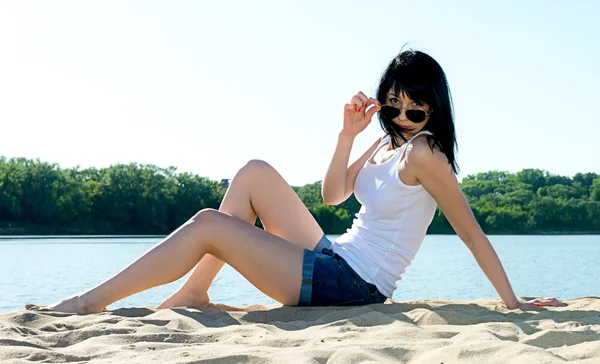 Девушка в солнечных очках на пляже — стоковое фото