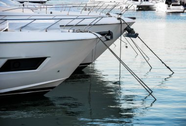 Şatafatlı yatlar gün batımında limana yanaştı. Modern motorlu teknelerin ve mavi suyun deniz parkı.